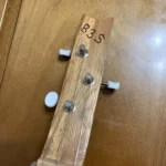 Front view of 3 string guitar with wooden headstock of Montecristo Cigar Box Guitar