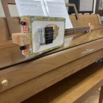 Side view of the whole body of the Romeo Y Julieta cigar box guitar handcrafted by Bob.