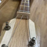 Close-up view of the neck attached to the headstock with tuners and 3 strings of Fat Bottom Betty CGB #43, a cigar box guitar handcrafted by Bob.