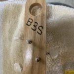 Closed up view of 3 closed gear tuners pegs where they attach to the handcrafted La Gloria Cubana cigar box guitar