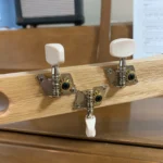 View of 3 closed gear tuners pegs where they attach to the handcrafted Guantanamera cigar box guitar