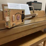 Side view of the whole body of the Punch cigar box guitar handcrafted by Bob.