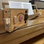 Side view of the whole body of the Punch cigar box guitar handcrafted by Bob.