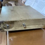 Back view of the bottom of the Craft/Stripped cigar box guitar, where the output jack, and chrome strap button attaches to the body.