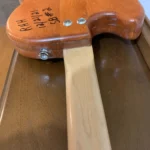 The image shows the back of a wooden guitar's body with the neck joint, featuring two screws and handwritten text: "RHH 4/21/21 SB #2."