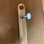 Close-up bottom view of the H Upmann Diddley Bow , a cigar box guitar handcrafted by Bob with attached the 1 tuner