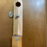 Closed up view of closed gear tuner where they attach to the handcrafted Alfred Dunhill Diidley cigar box guitar